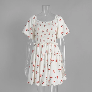 Detail view of square neck puff sleeve dress with red cherry print and smocked chest