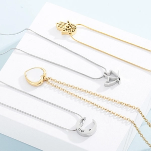 Detail of assorted gold and silver necklaces with butterfly, heart and hand pendants