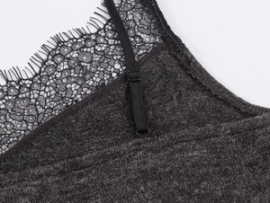 Détail de maille côtelée gris foncé avec bordure en dentelle noire et bretelle fine