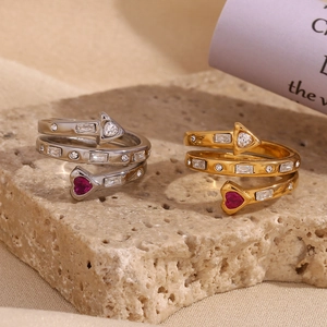 Detail of 18K gold and silver triple heart arrow rings with zircons on stone base