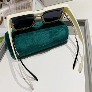 Oversized creamy white square sunglasses with dark grey lenses and green velvet case