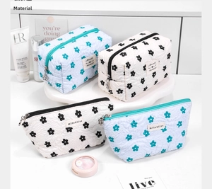 Detailed close-up of quilted floral cosmetic bags set with metal zipper and soft texture