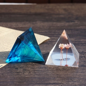 Pyramid silicone resin molds showing deep blue ink effects and pink dried flower casting