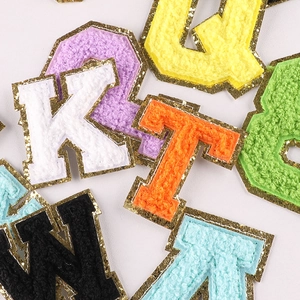 Chenille towel embroidery letter patches with gold glitter sequins on light background