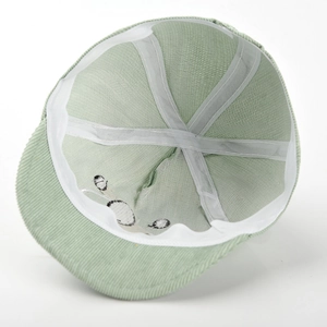 Vue détaillée de l'intérieur d'une casquette bébé en velours côtelé vert avec doublure