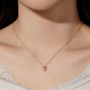 Close-up of a gold reindeer antler necklace with zircon on a model wearing lace clothing