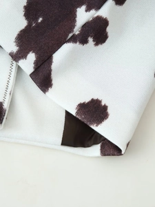 Close-up of cow print jacket fabric showing high-quality stitching and dark lining details