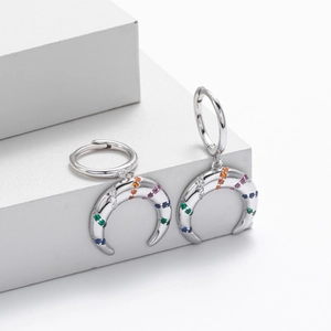 Detail of S925 sterling silver hoop earrings with crescent pendants and colorful zircons