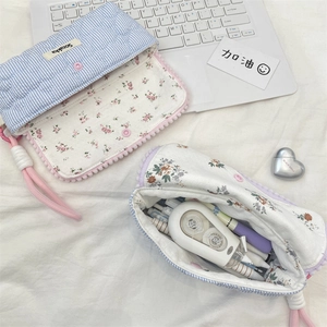 Detail of floral pencil case showing blue stripes, fabric lining and zipper closure
