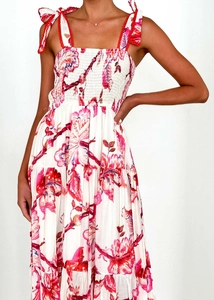 Detail of red floral print with smocked bodice and wavy shoulder strap on maxi dress