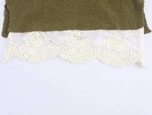 Detail of olive green knit fabric with elegant cream floral lace trim at the hem