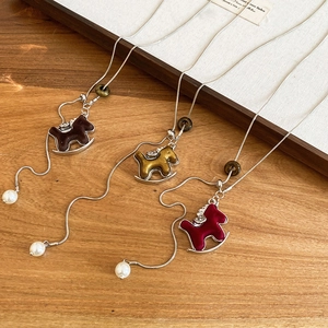 Gros plan de pendentifs cheval à bascule vintage avec perles sur bois