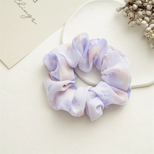 Detail of floral chiffon scrunchie with purple and brown tie-dye pattern on ceramic tray