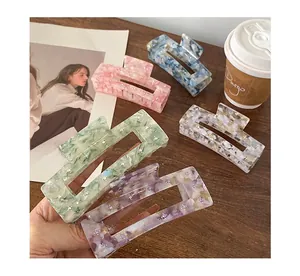 Detail of large acetate hair claws with rhinestones in multiple pastel marble colors