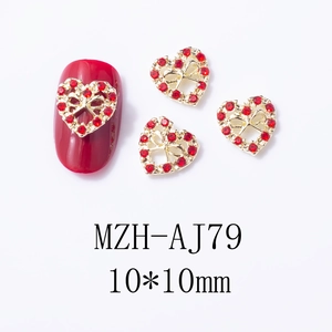 Détail d'un charm pour ongles coeur rouge 10x10mm avec nœud doré évidé