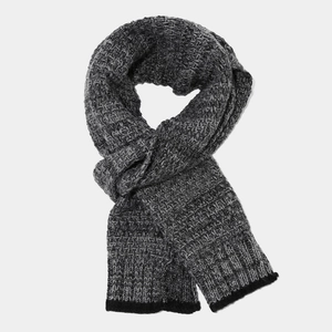Dettaglio della sciarpa in maglia invernale con trama grigio melange e bordi a coste neri