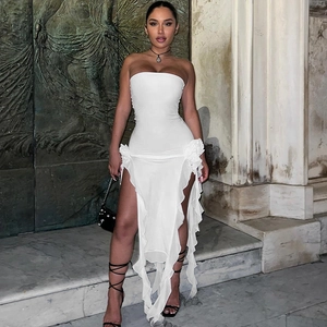 Détail d'une robe bustier blanche avec bordure à volants et fente haute sur la jambe