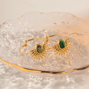 Detailed shot of gold vintage rings with green malachite stones in a glass dish
