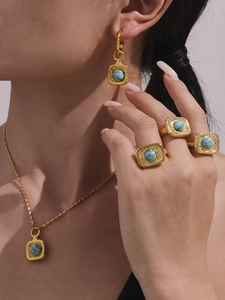 Nahaufnahme eines goldenen Türkis-Schmucksets mit Hammerschlag-Textur an einem Model