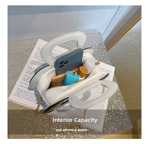 Internal capacity of the white handbag showing space for phone, cosmetics, and daily items