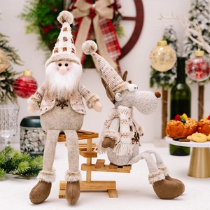Detailansicht von Plüsch-Weihnachtsmann und Rentier auf einer Holzleiter in Festdeko