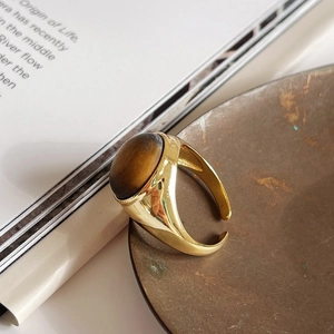 Detail of a vintage-style adjustable gold silver ring set with a natural tiger eye stone