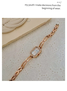 Macro view of rose gold rectangular watch with rhinestone bezel and chain bracelet