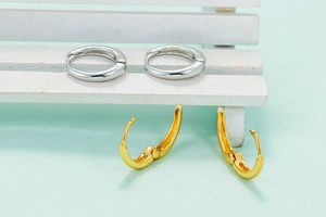 Minimalist U-shaped hoop earrings in gold and silver finish on a clean background