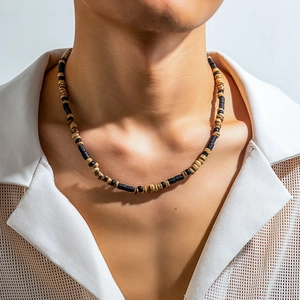 Men's bohemian beaded necklace with black and white wood beads on a male model