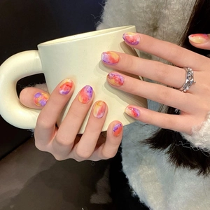 Artistic marble pattern press-on nails with orange and purple smudge effect design