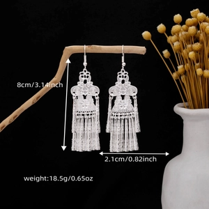 Detailed view of bohemian silver tassel earrings with 8cm length and floral hollow patterns