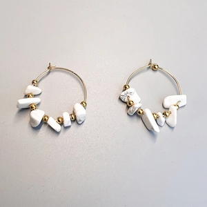 Detail view of gold hoop earrings featuring irregular white stone beads and gold accents