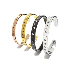Detail of four open stainless steel bracelets in gold, silver, rose gold and black finish