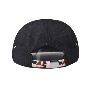 Detail view of the black denim flat brim cap featuring a camouflage adjustable back strap