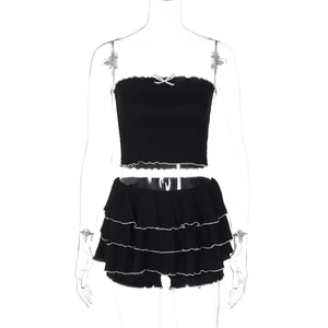 Détail du haut bustier noir avec nœud rose et minijupe à volants multicouches