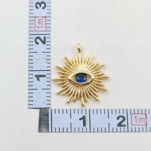 Macro shot of gold sunburst Evil Eye pendant with blue stone showing size measurement