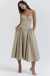 Detail of beige corset style midi dress with spaghetti straps and pleated A-line skirt