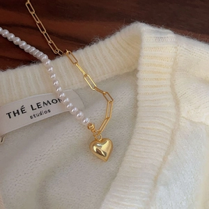 Asymmetric pearl and gold paperclip chain necklace with a puffed heart pendant
