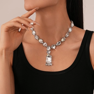 Close-up of statement silver necklace with teardrop and square-cut shimmering crystals