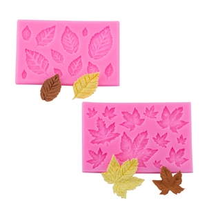 Pink silicone leaf molds set with brown and green fondant leaf shapes on white background