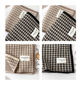 Detailed knit texture of houndstooth scarves in brown and black neutral tones