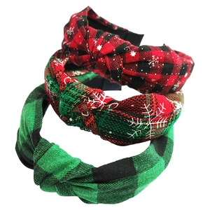 Detailed view of three knotted headbands in red and green festive plaid patterns