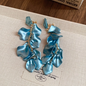 Detailed macro of blue flower petal tassel earrings with elegant golden metal chains