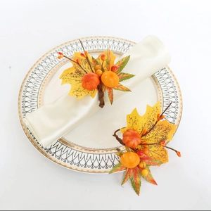 Détail de ronds de serviette citrouille et feuille d'érable sur assiette blanche