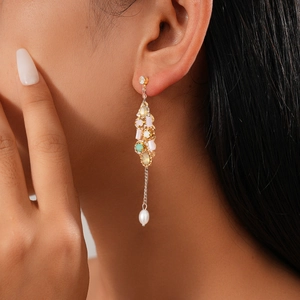 Vue détaillée d'une boucle d'oreille longue en or avec opale et perle sur mannequin