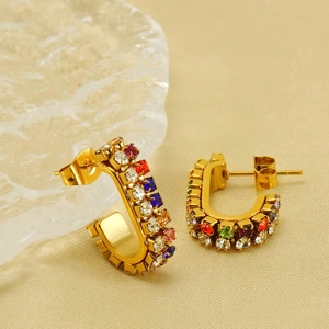 U-shaped gold titanium earrings with colorful cubic zirconia crystals on beige fabric