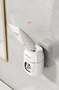 Close-up of wall-mounted toothpaste dispenser with flexible silicone screw interface