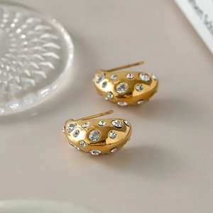 Close-up of 18k gold plated chunky drop earrings with sparkling rhinestones and pearls