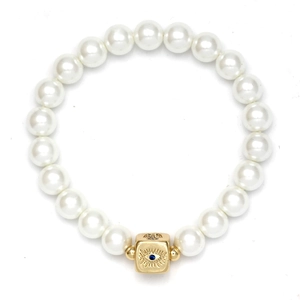 Makro-Detail des goldenen Würfels mit bösem Blick und Medusa auf Perlenarmband