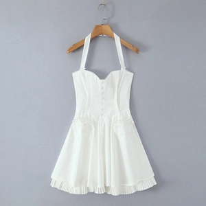 White halter neck dress with button detailing and pleated skirt on a wooden hanger